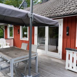 Ferienhaus Högalund, Veranda mit Esstisch und Sonnenschirm